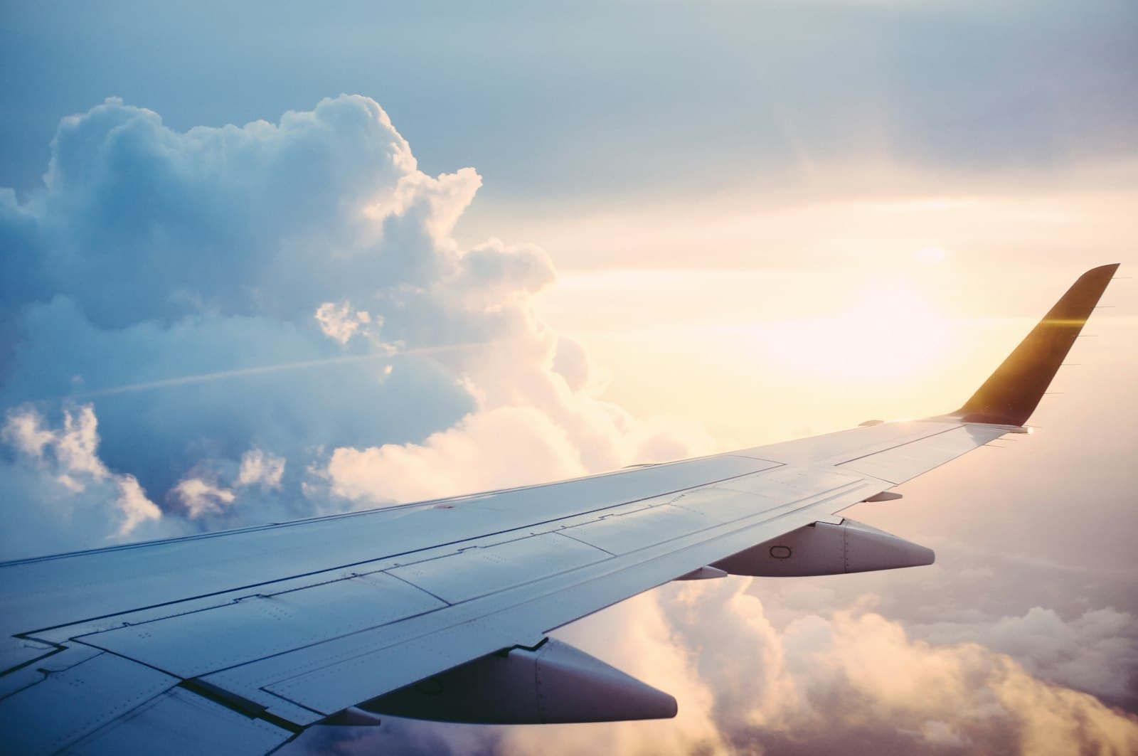 Airplane wing above clouds on an international flight